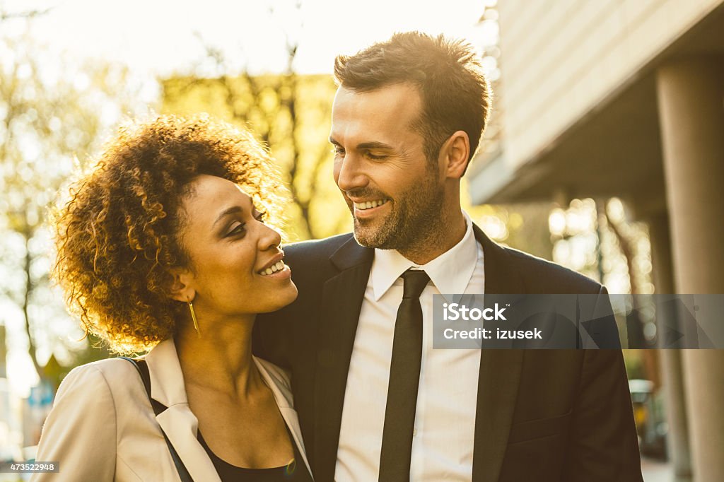 Outdoor portrait of flirting elegant couple Outdoor portrait of cheerful, elegant couple - afro amercian woman and caucasian man at sunset. Close up of faces. 2015 Stock Photo