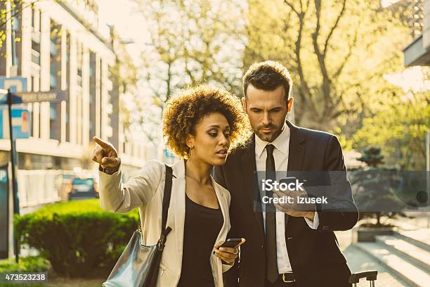 Outdoor Portrait Of Two Business People With Smart Phones Stock Photo - Download Image Now