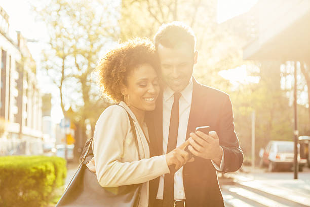 istock Elegant couple using smart phone outdoor 473523286