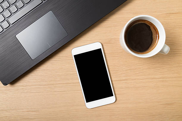 istock Smart phone, laptop and cup of coffee on work table 473523346