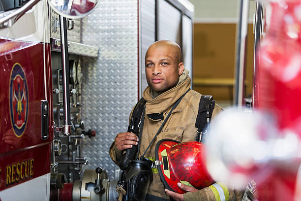 istock African American fire fighter standing next to truck 473525616