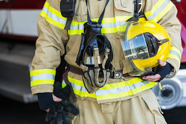 istock Cropped view of fire fighter holding helmet 473525622