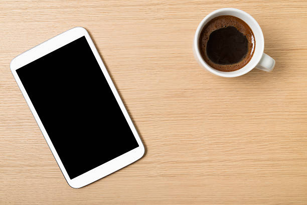 istock Digital tablet and cup of coffee on wooden table 473528664