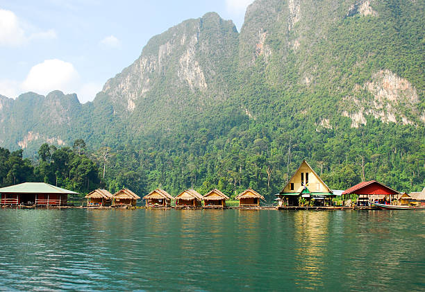 istock Tropical lakeside hut and wooden boat 473529156