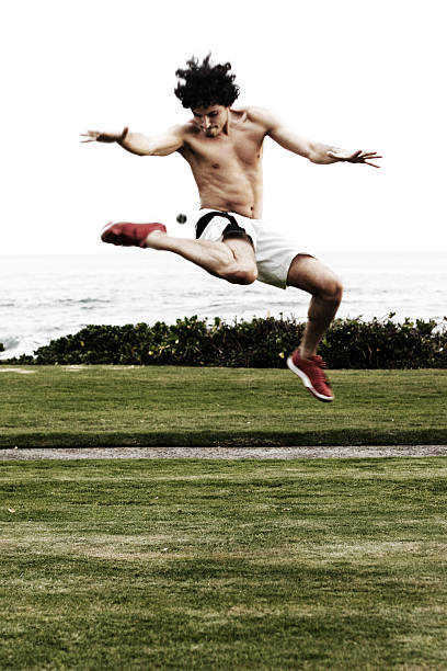 istock Shirtless Young Man Airborne Playing Hacky Sack 473529598