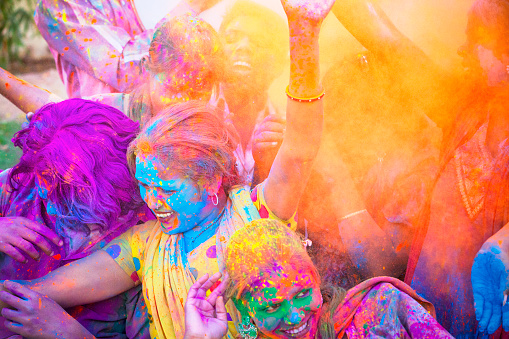 Group of young Indian friends covered in colored dye celebrating Holi festival in Jaipur, India.