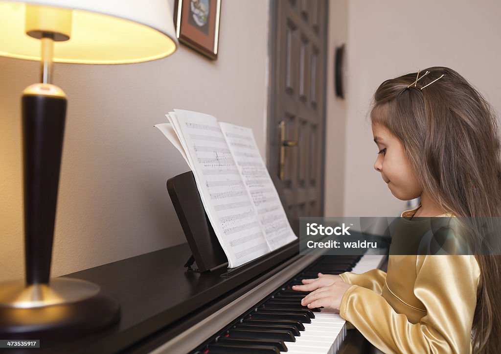 Little girl playing the piano Little girl playing the piano with notes Beautiful People Stock Photo