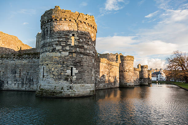 Castle and moat, Beaumaris, Wales - February 21, 2015: Castle and moat, Beaumaris Castle on the Isle of Anglesey, medieval military architecture, castle wall with towers next to a moat. Other buildings can be seen behind the castle  keep fortified tower photos stock pictures, royalty-free photos & images