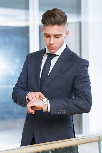 istock Businessman looking at his watch in the office 473549250