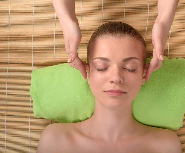 istock Beautiful young woman getting relaxing head massage. Top view 473555220