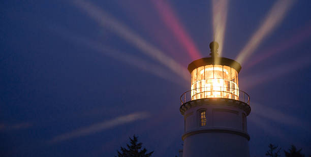 Lighthouse Beams Illumination Into Rain Storm Maritime Nautical A perfect storm is just the right weather to make a lighthouse earn its keep for weary travelers lanterns at night stock pictures, royalty-free photos & images
