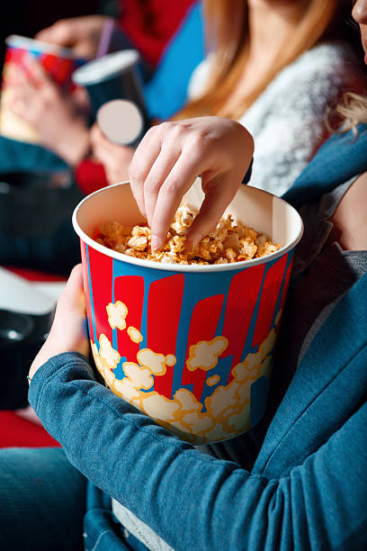 istock Woman eating popcorn in cinema 473557108
