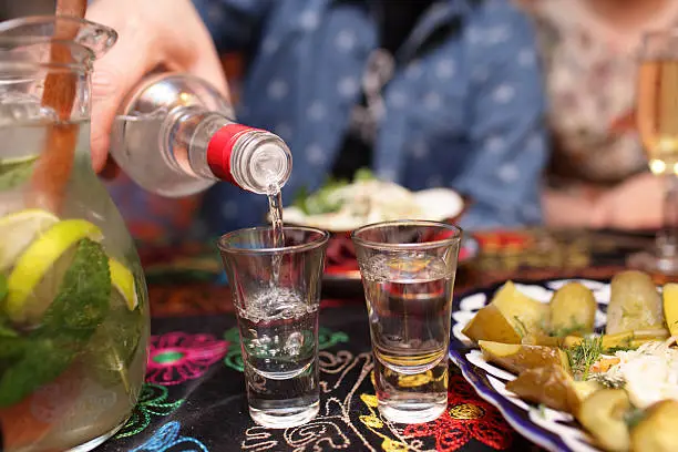 Person pouring vodka in the asian restaurant