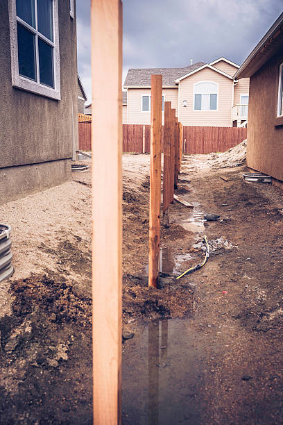 istock New fence construction. Fence posts cemented into ground 473559130