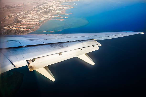 istock Wing of the plane on blue sky background 473563538