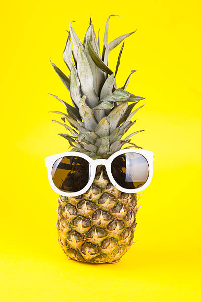 istock Funny pineapple in sunglasses on yellow background 473563822