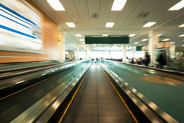 Motion blurred image of a moving walkway Long exposure of an indoor pedestrian moving walkway with motion blur airport travelator stock pictures, royalty-free photos & images