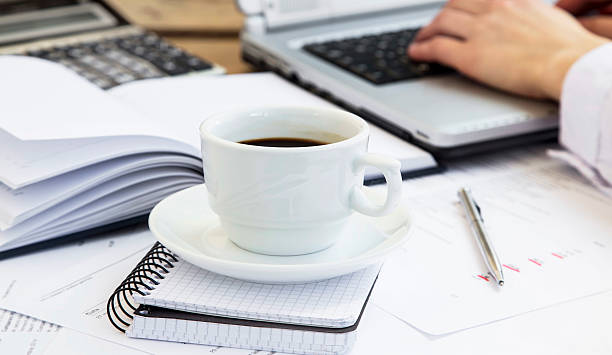 istock Coffee Cup at Office with Financial Papers and Businessman Worki 473564932
