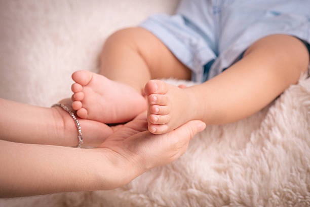 Pés de Bebê na mão da mãe - fotografia de stock