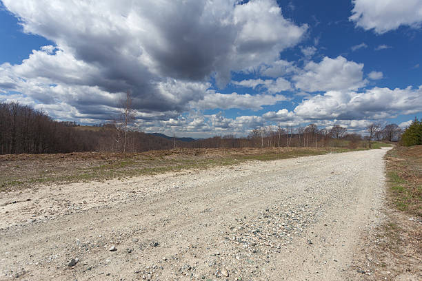 istock Empty dirt road in mountain at sunny day 473569086