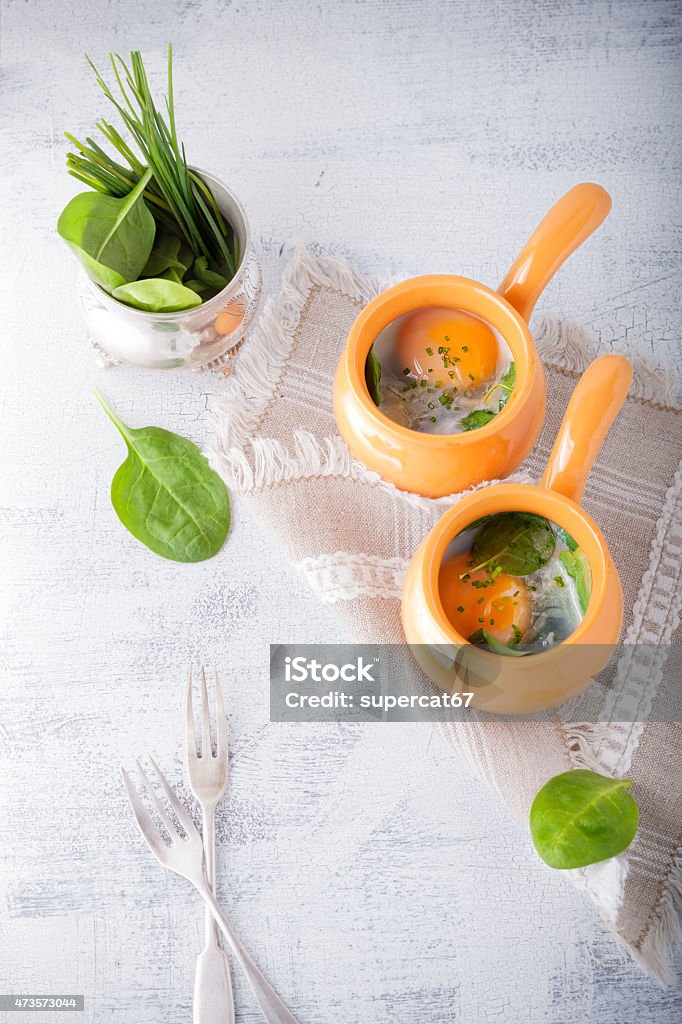 Baked eggs with spinach Casserole with eggs, spinach and parmesan for breakfast 2015 Stock Photo