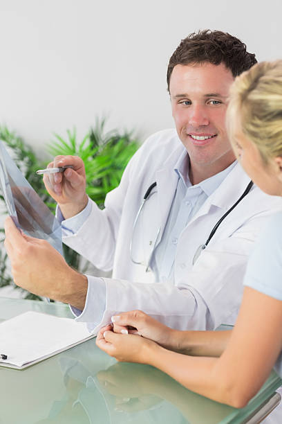 istock Smiling doctor showing a patient something on xray 473573142