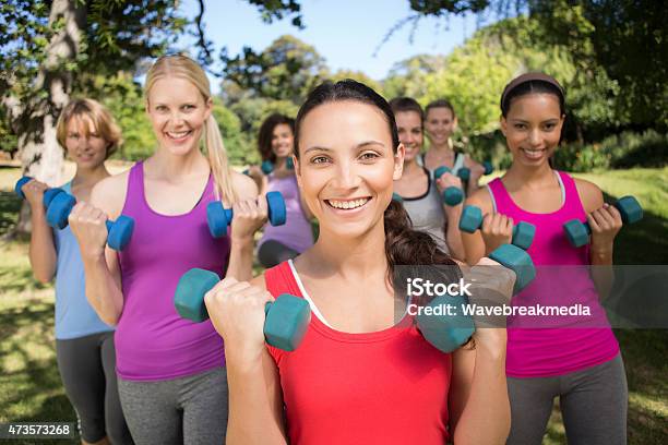 Fitness Group Lifting Hand Weights In Park Stock Photo - Download Image Now - 20-24 Years, 20-29 Years, 2015