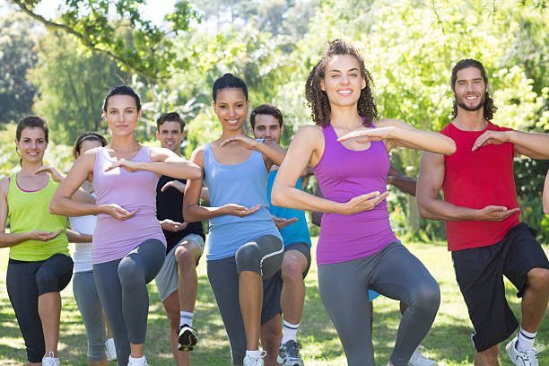 istock Fitness group doing tai chi in park 473573748