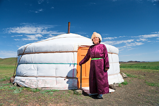 Mongolian woman in national clothing, ger (yurt) in the background.http://bem.2be.pl/IS/mongolia_380.jpg