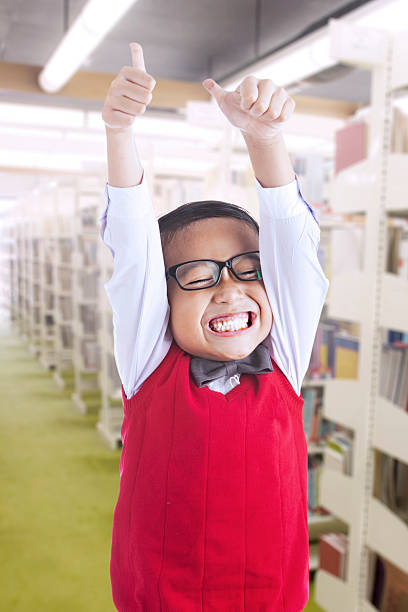 istock Boy cheers happily in the library 473578124