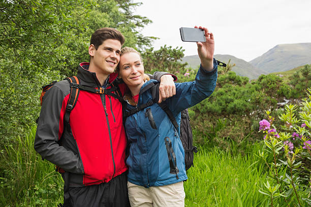 istock Happy couple on hike taking a selfie 473578388