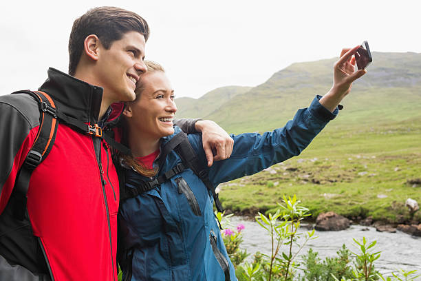istock Athletic couple on hike taking a selfie 473578414