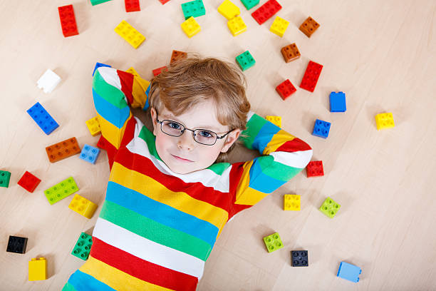 istock Little kid boy playing with lots of colorful plastic blocks 473582790