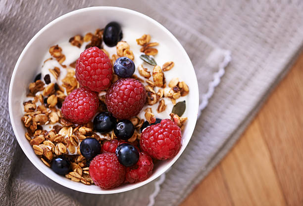 Start the day the healthy way High angle shot of granola, yoghurt and berries in a bowl on a tabletophttp://195.154.178.81/DATA/i_collage/pu/shoots/804614.jpg granola photos stock pictures, royalty-free photos & images