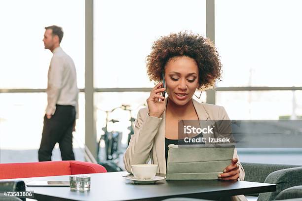 Afro American Businesswoman Using A Digital Tablet In Hotel Bar Stock Photo - Download Image Now