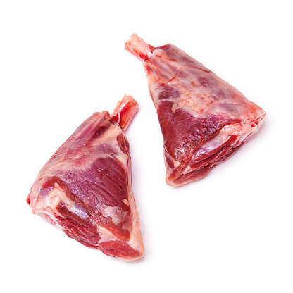Uncooked goat meat leg shanks for roasting isolated on a white studio background.Uncooked goat meat leg shanks for roasting isolated on a white studio background.