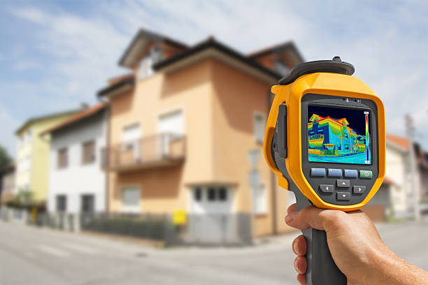 istock Hand using equipment to record Heat Loss at the House 473586342