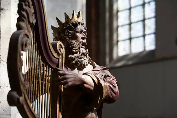 Centuries old wooden sculpture of King David playing a harp in Breda's Great Church, or Church of our Lady, in the Netherlands