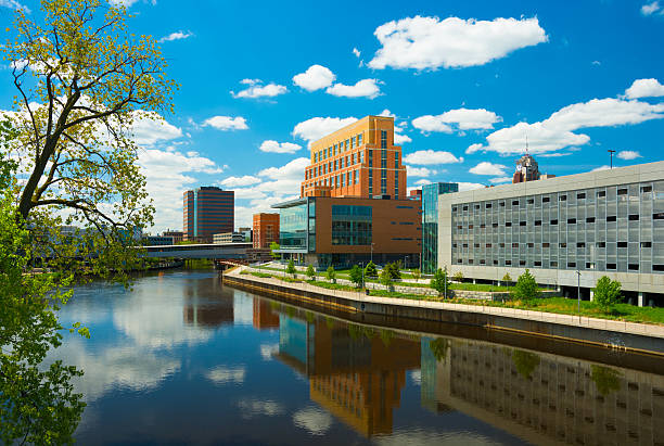 istock Lansing downtown buildings and Grand River with clouds 473594226