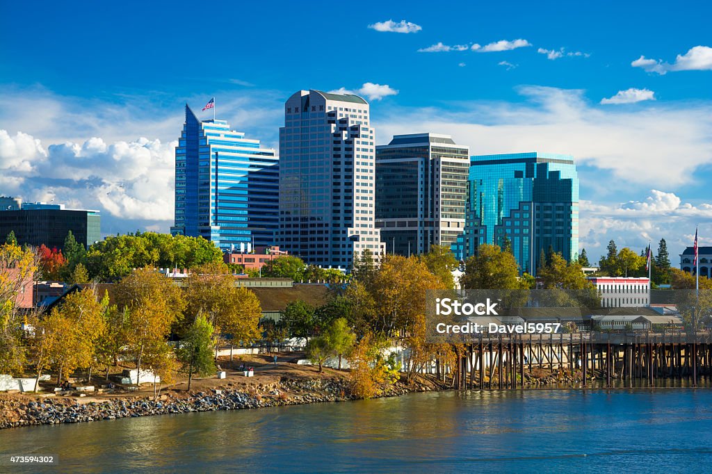 Sacramento downtown skyline during Autumn Sacramento downtown skyline during Autumn with Autumn colored trees in the foreground, with the Sacramento River, and dramatic clouds in the background. Sacramento Stock Photo