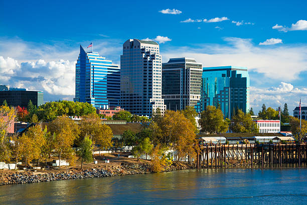 Sacramento downtown skyline during Autumn Sacramento downtown skyline during Autumn with Autumn colored trees in the foreground, with the Sacramento River, and dramatic clouds in the background. sacramento photos stock pictures, royalty-free photos & images