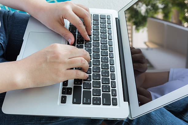 istock Woman working with laptop computer sitting at swimming pool 473598726