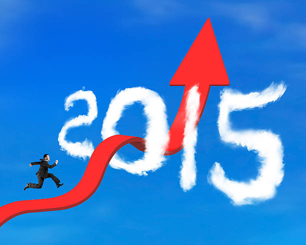 istock Businessman running on arrow upward trend line through 2015 clou 473599548