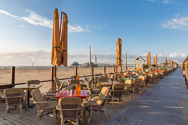 holandés terrazas a lo largo de la playa con vista al muelle de scheveningen - bancal fotografías e imágenes de stock