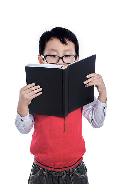 istock Asian boy reading book - isolated on white 473602664