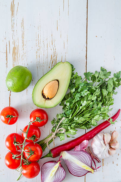 istock Guacamole ingredients - avocado, tomatoes, onion, garlic, lime 473604078