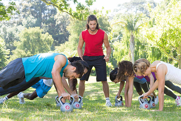 istock Fitness group planking in park with coach 473606594