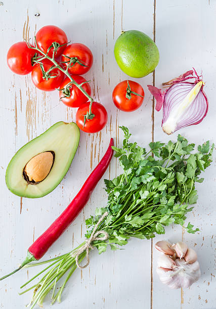 istock Guacamole ingredients - avocado, tomatoes, onion, garlic, lime 473607998