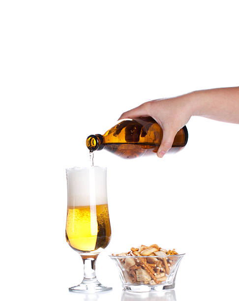 istock Beer pouring from green bottle into glass and crackers  isolated 473608624