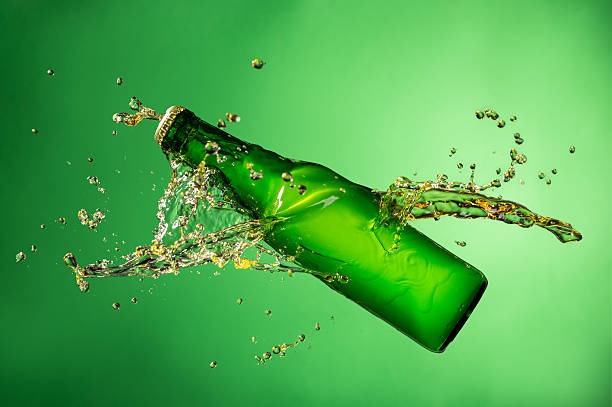istock Bottle of beer with splash, on green background 473609268